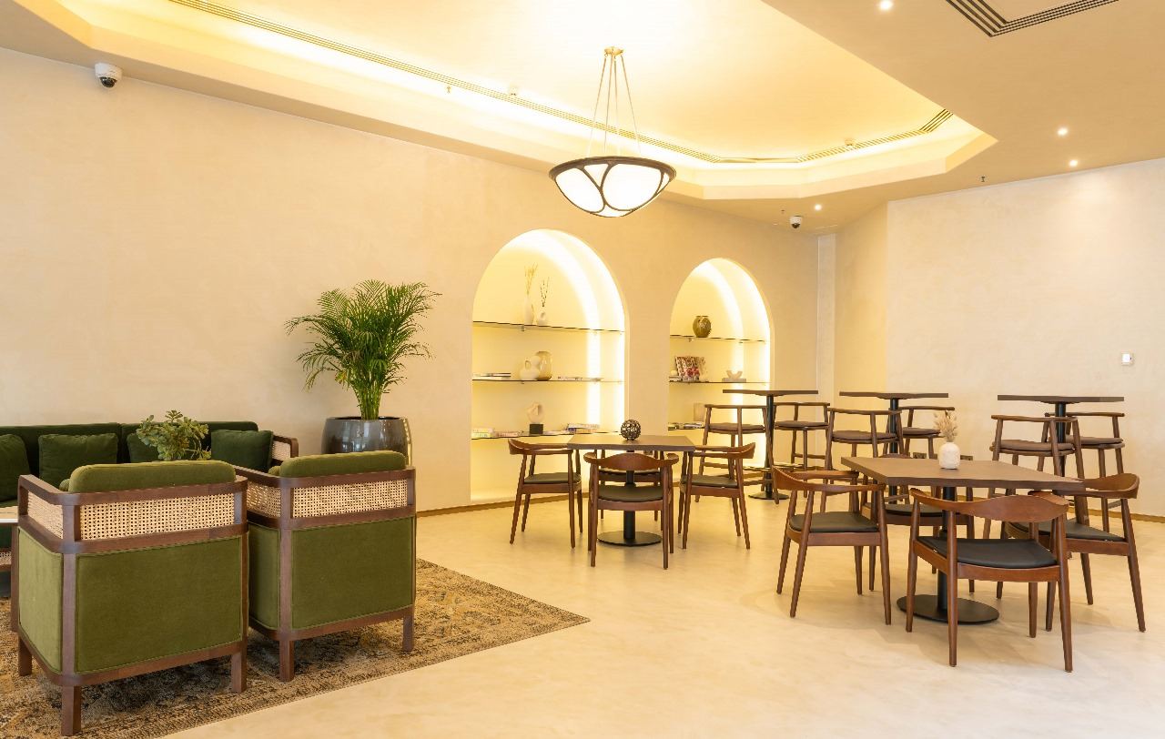 Cafe with backlit arched display niches and green velvet seating