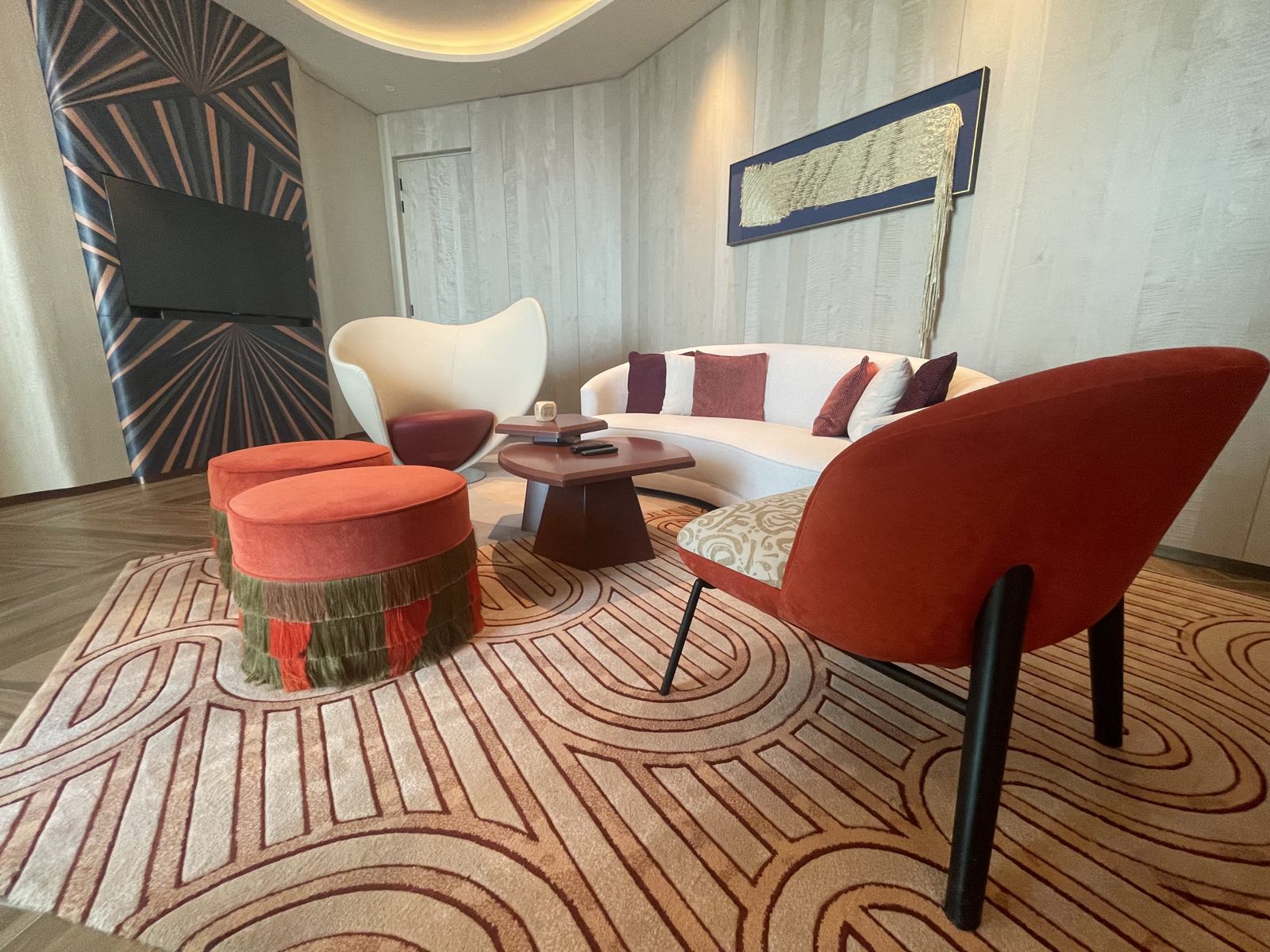 Hotel suite lounge with curved sofa and patterned rug