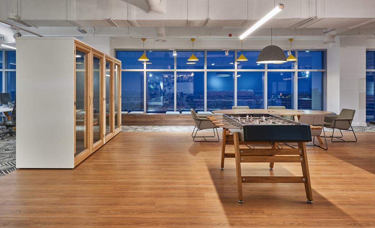 Timber-framed glass meeting rooms along an open office floor