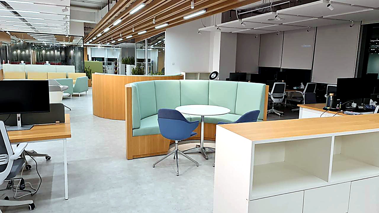 Open workstations with a blue tub chair and a timber slat ceiling