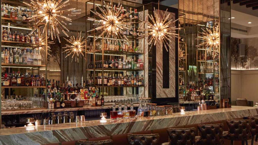 Marble bar counter with lit back shelving and starburst pendant lights