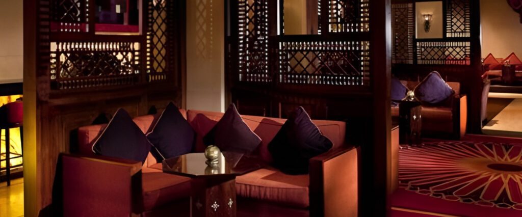 Lounge sofas with carved timber screens and red patterned carpet