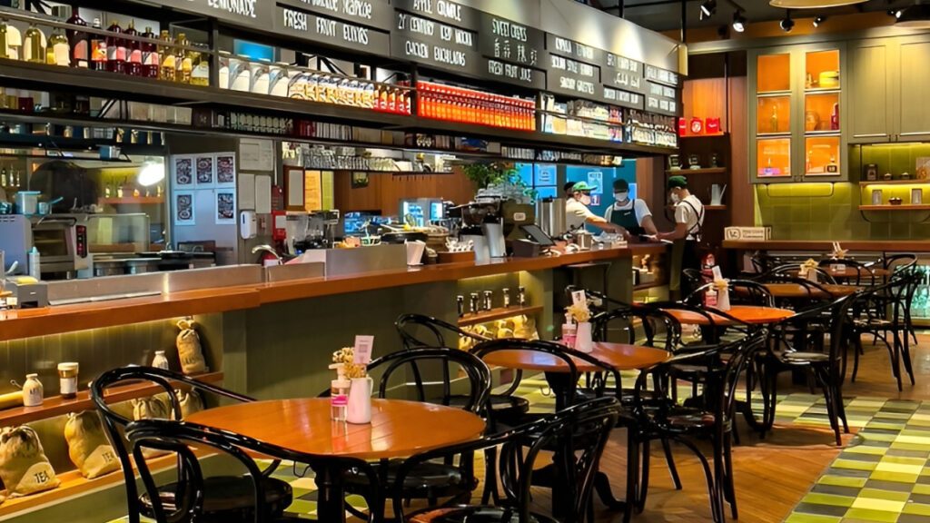 Cafe dining area with bentwood chairs, open kitchen counter and chequered floor