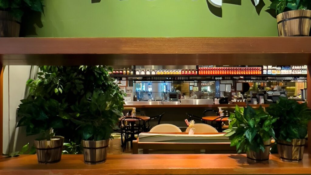 View through a timber planter screen to banquette seating and the counter
