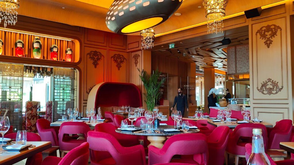 Dining room with pink velvet chairs, carved wall panels and a domed booth