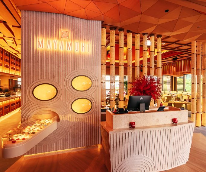 Reception desk with fluted stone wall and backlit round niches