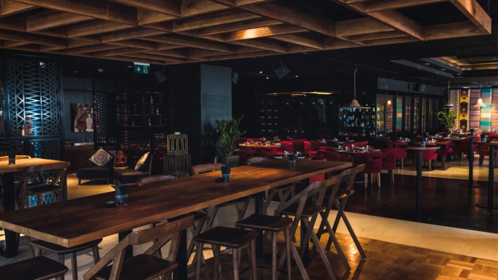 Long communal table under a timber coffered ceiling with lattice screens