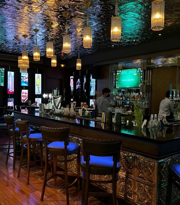 Bar counter with blue stools, pendant lights and a pressed metal ceiling