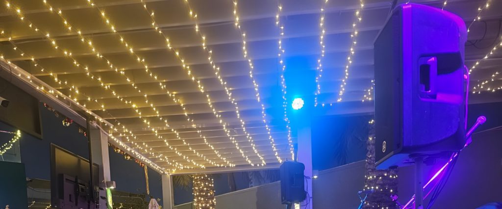 Terrace canopy strung with fairy lights over a stage area