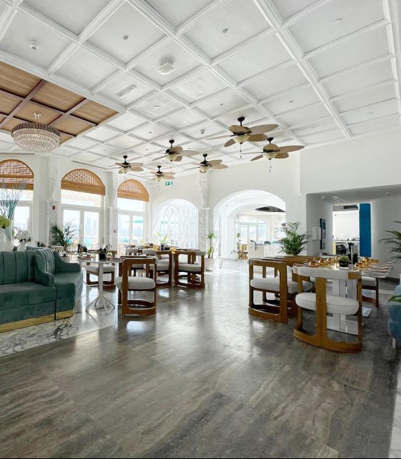 Bright dining hall with coffered white ceiling and ceiling fans