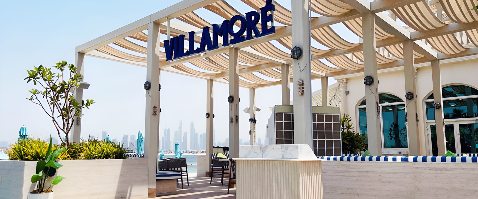 Rooftop terrace pergola with Villamore signage and Dubai Marina skyline