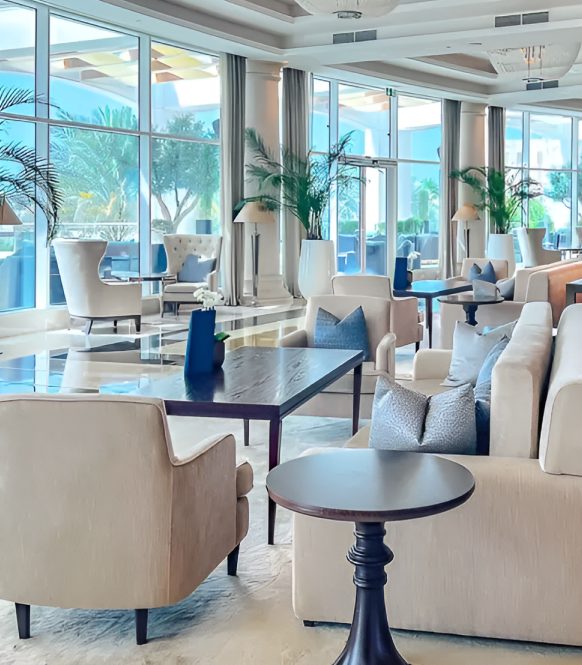 Hotel lounge with cream armchairs beside floor to ceiling windows