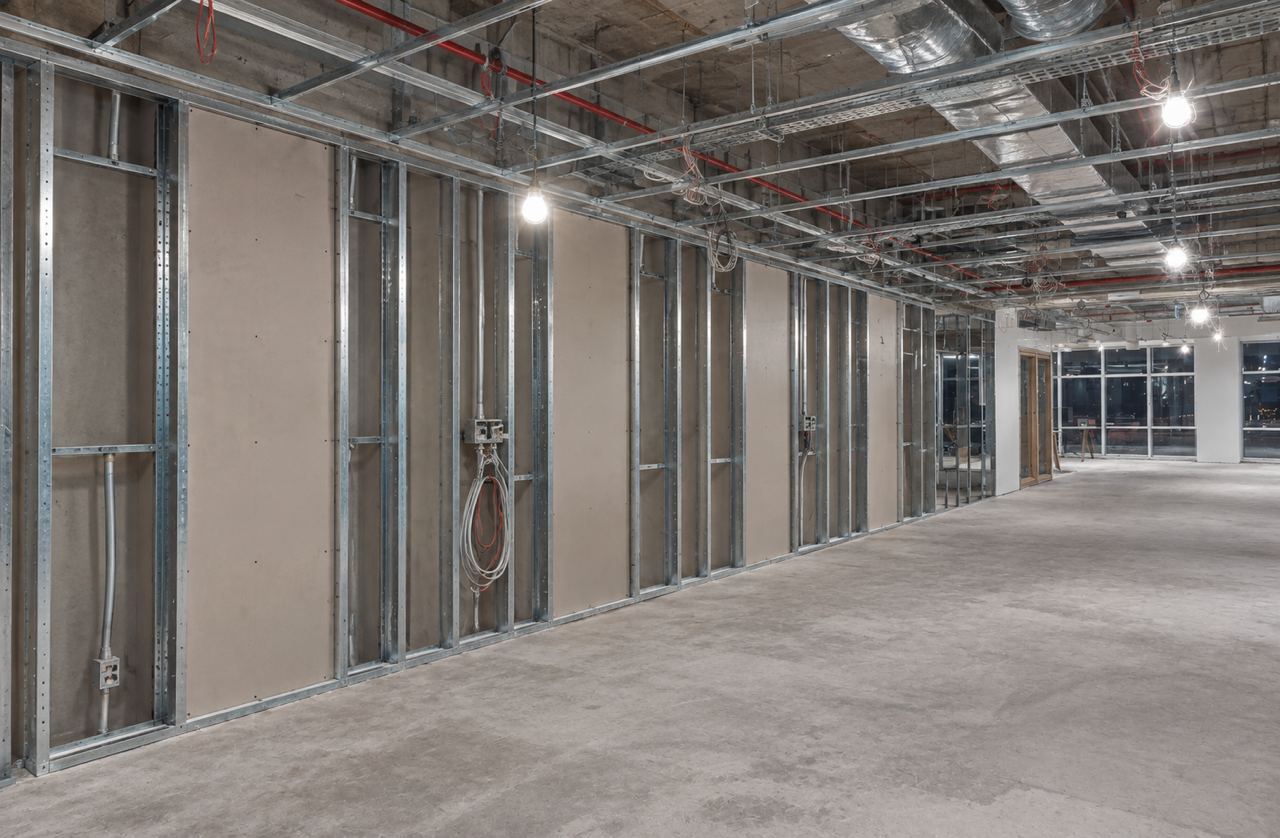 Reception with a fluted black desk under a slatted timber ceiling, at first fix, stud walls and services (AI illustration)