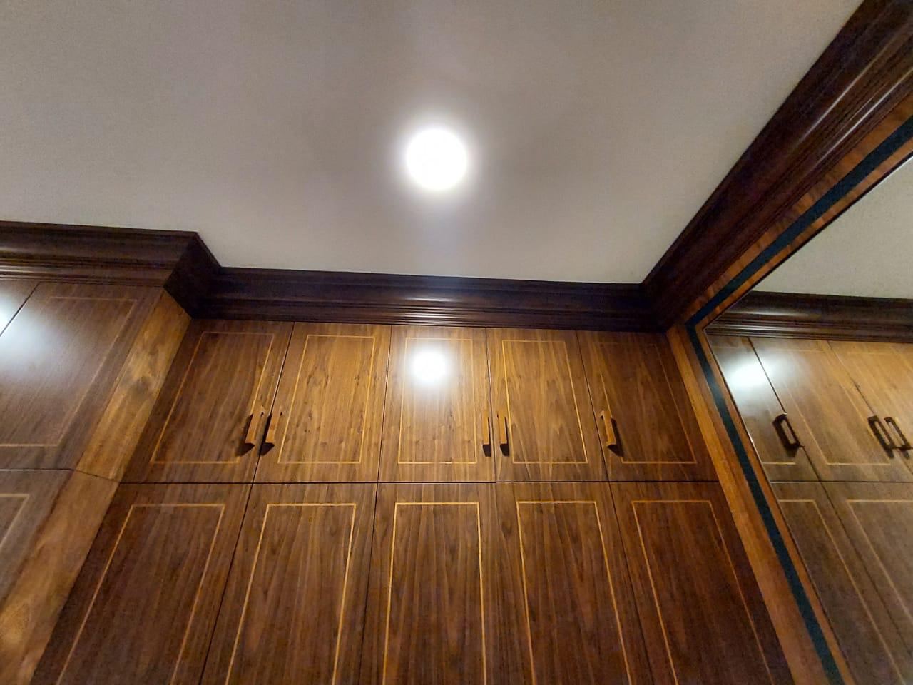 Full height walnut wardrobes with inlaid panels and crown moulding